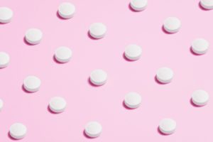 white round capsule on pink background close up photography